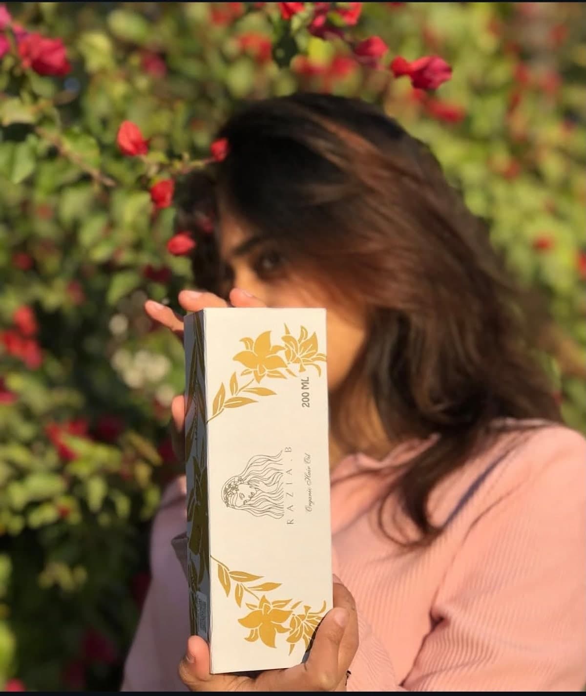 Holding the Razia B. Organic Hair Oil gift box